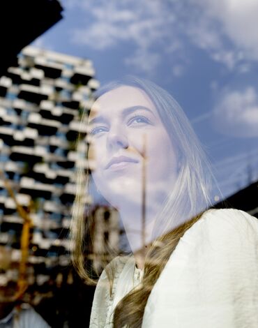 Chica mirando por una ventana.