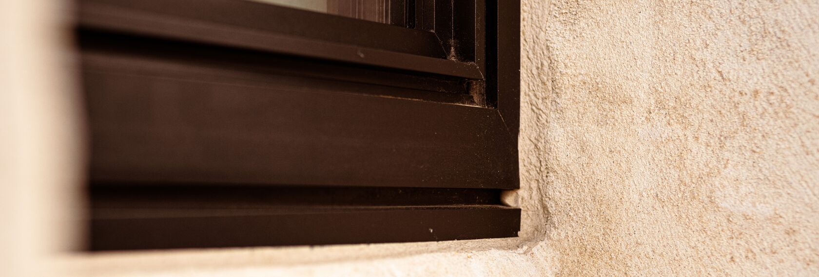 Detail view of concealed drainage in a black aluminium window.