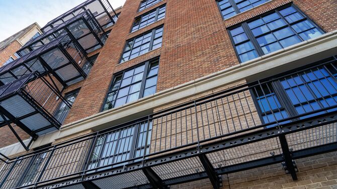 Edificio de apartamentos de mediana altura, de ladrillo, con ventanas con apariencia de acero.