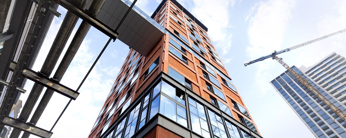 Edificio alto de color naranja visto desde abajo.