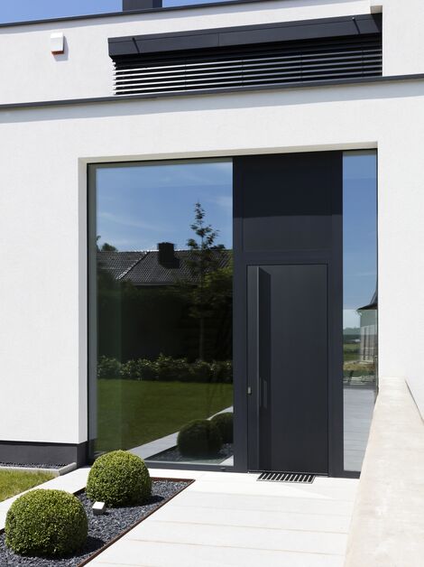 Puerta panelada de aluminio negro en hogar moderno.