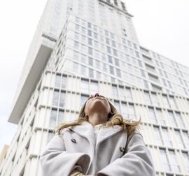 Mujer mirando a un edificio alto
