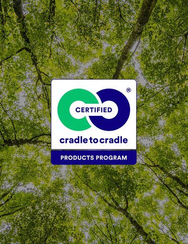 Logotipo de Cradle to Cradle delante de las copas de los árboles verdes.