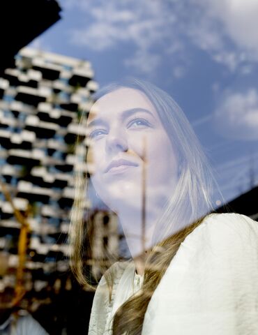 Chica mirando por una ventana.
