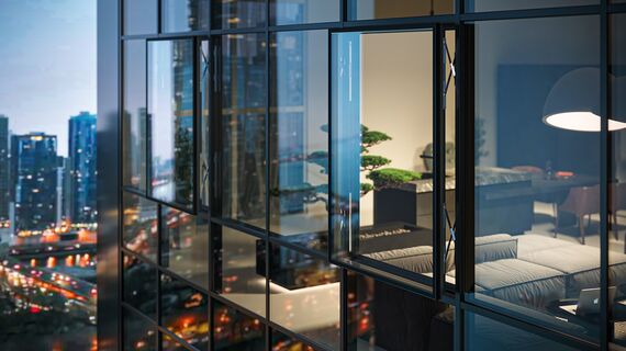 Night view of a high-rise building with an open parallel window in the glass façade.
