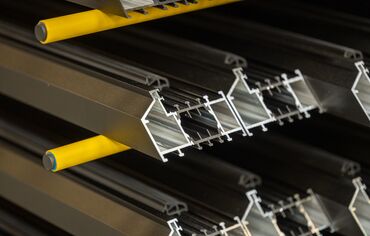 Aluminium profiles in a yellow rack.