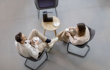 Vista superior de un hombre y una mujer sentados en una mesa tomando café.