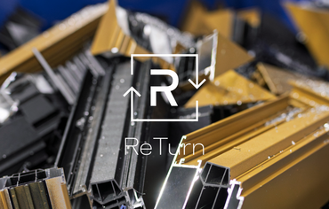 ReTurn logo in front of pile of aluminium scrap in blue bin.